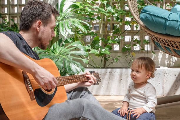 Father playing guitar for his 14-month-old son Comptines enfants